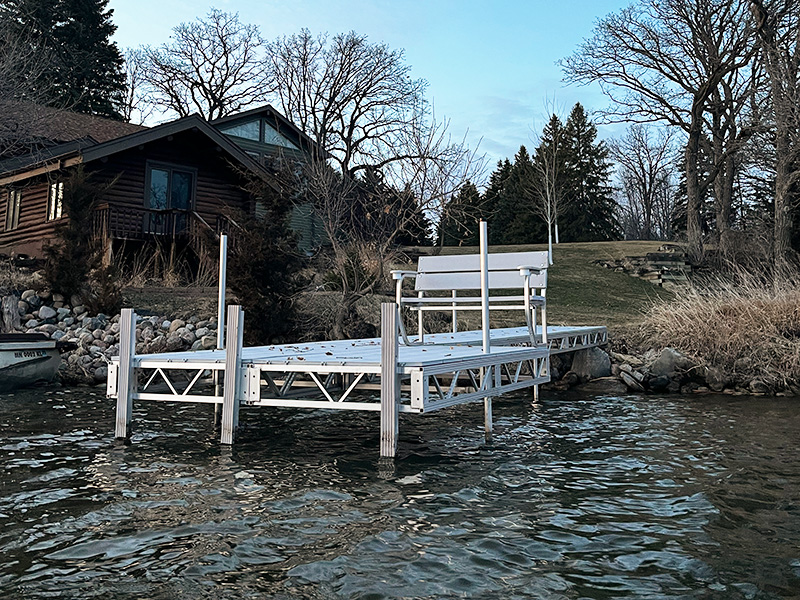 Aluminum lake dock with bench seating near shoreline in West Central Minnesota.