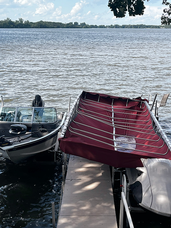 Boat and pontoon with canopy cover on dock in West Central Minnesota.