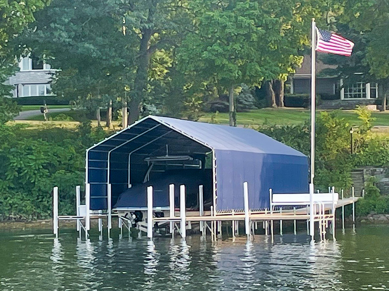 Boat stored under a blue canopy on a lake dock in West Central Minnesota.