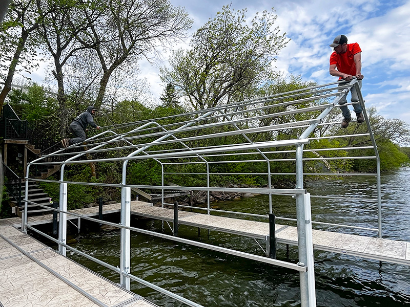 West Central Docks crew assembling an aluminum boat lift canopy frame on a lake dock in West Central Minnesota.