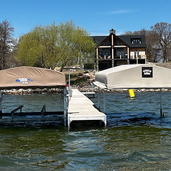Dual covered boat lifts connected by aluminum dock in West Central Minnesota.