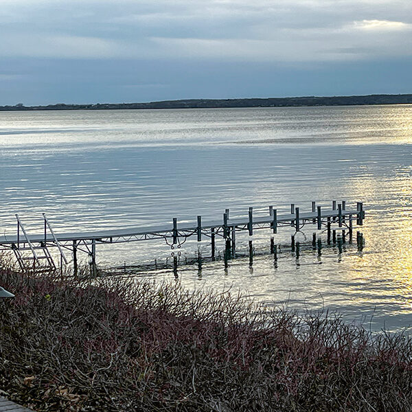 Aluminum lake dock extending into calm water at sunset in West Central Minnesota.
